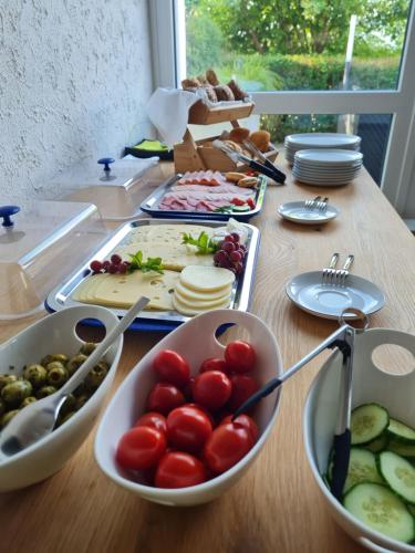 a table topped with bowls of tomatoes and other foods at MUT.HAUS in Bischofsheim an der Rhön