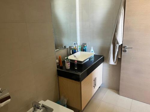 een badkamer met een wastafel en een spiegel bij Appartement de luxe, front de mer Plage des nations in Sale
