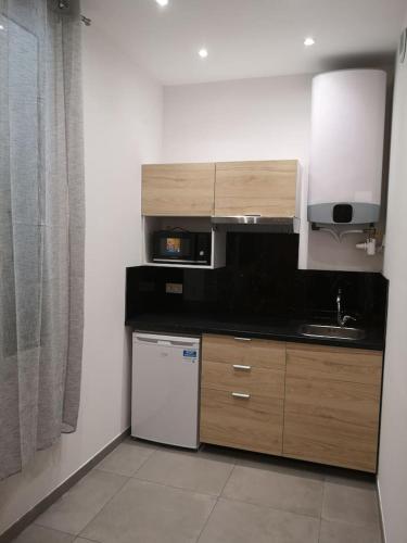 une cuisine avec un réfrigérateur blanc et un évier dans l'établissement maison de papa, à Nice