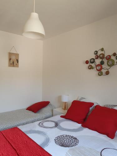 a bedroom with a bed with red pillows at la java in Saint-Cyran-du-Jambot