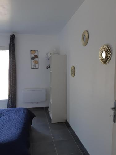 a bedroom with a white refrigerator and a bed at la java in Saint-Cyran-du-Jambot