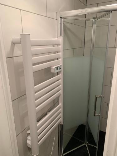 La salle de bains est pourvue d'une douche et d'une porte en verre. dans l'établissement Au Coeur du village de Prémanon, à Prémanon