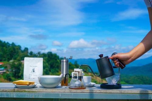 a person is making a drink on a table at Mon Jam Memory Camp in Mon Jam