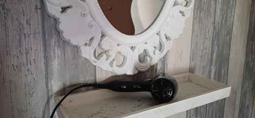 secador de pelo en un estante bajo un espejo en De Snoeperij, en Dirksland