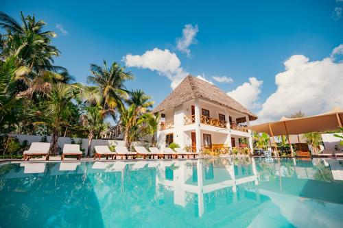 una piscina con sedie e un edificio di Mayai Ocean Resort a Bwejuu