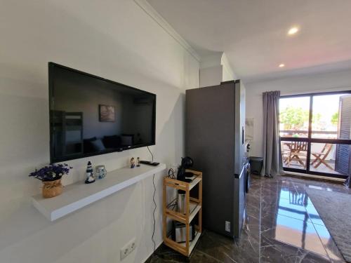 a living room with a large flat screen tv on the wall at Stunning Apartment Near Clubs in Albufeira