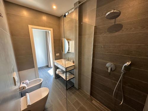 uma casa de banho com um chuveiro, um WC e um lavatório. em Split Rooftop Suites em Durrës