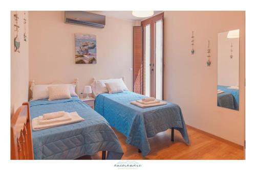 1 dormitorio con 2 camas individuales y espejo en Ancóramare view, en Stintino
