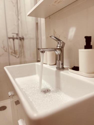a sink with water running from a faucet at Apartment Rovci 2 in Slatine