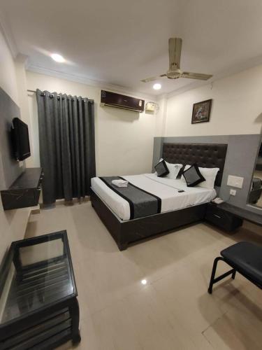 a bedroom with a large bed and a television in it at HOTEL VIGHNESHWARA INN in Vijayawāda