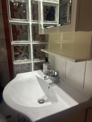 a white sink in a bathroom with a window at White Paradise in Paleo Tsifliki