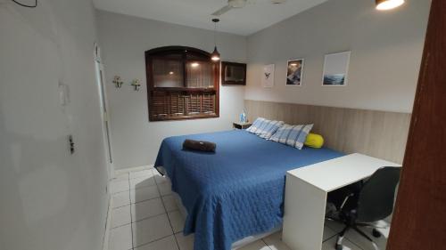 Schlafzimmer mit einem Bett, einem Schreibtisch und einem Fenster in der Unterkunft Lindo e novo ao lado da ETPC in Volta Redonda