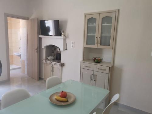 a kitchen with a table with a plate of fruit on it at Captain John's Apartment in Diafani