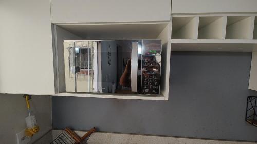 a microwave in a kitchen with its door open at Lindo Apartamento completo ao lado ETPC VR in Volta Redonda