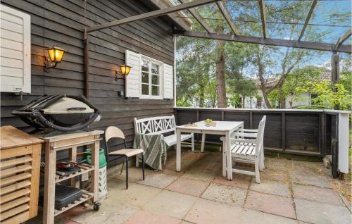 eine Terrasse mit einem Tisch, Stühlen und einem Grill in der Unterkunft Lovely Home In Solrd Strand With Wifi in Karlstrup Strand