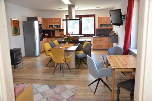 a kitchen and dining room with a table and chairs at Apartmán Nad potokem in Český Rudolec