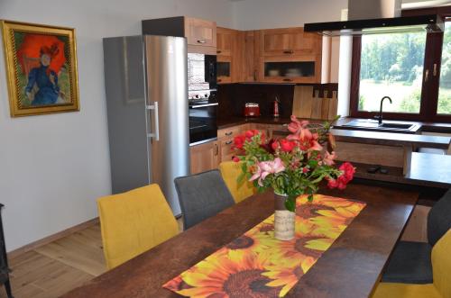 a kitchen with a table with a vase of flowers on it at Apartmán Nad potokem in Český Rudolec