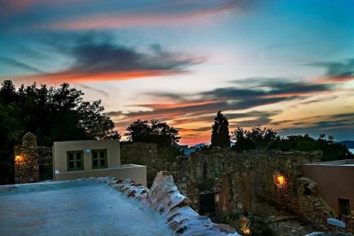 a sunset over a house with snow on the ground at Renovated old traditional House in Kos
