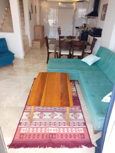 a living room with a blue couch and a table at Stonehouse Aparts Dublex 3+1 mit Meerblick und Jakuzzi Kalkan No:5 in Kalkan