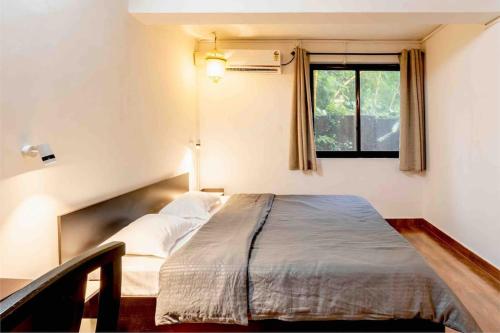 Ce lit se trouve dans un dortoir doté d'une fenêtre. dans l'établissement The Burrow in South Goa., à Dabolim