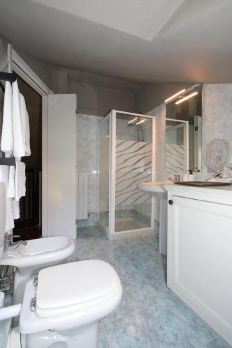 a white bathroom with a toilet and a sink at wonderful lake front appartment near Bellagio in Limonta