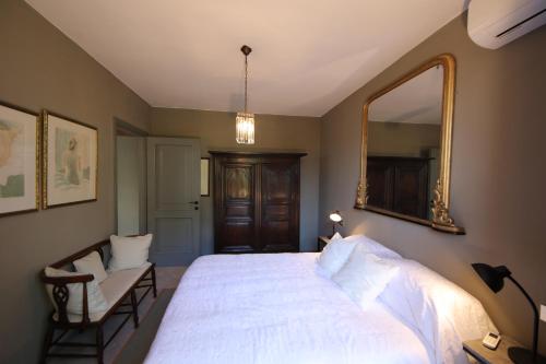 a bedroom with a large white bed and a mirror at wonderful lake front appartment near Bellagio in Limonta