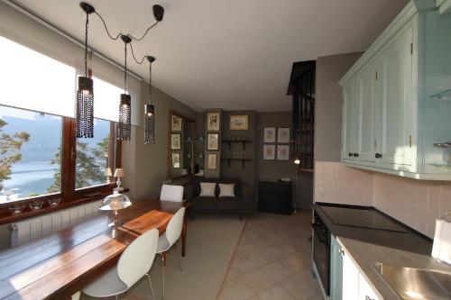 eine Küche mit einem Tisch und Stühlen sowie ein Wohnzimmer in der Unterkunft wonderful lake front appartment near Bellagio in Limonta