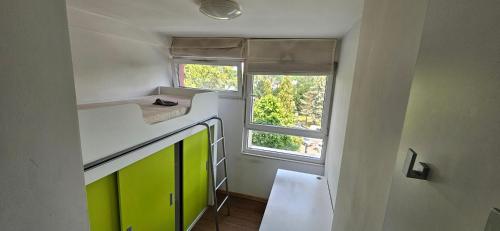 małą kuchnię z zielonymi szafkami i oknem w obiekcie Starter 1 we Wrocławiu