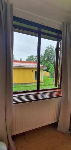 una ventana con vistas a una casa amarilla en Private Room in Shared House-Close to University and Hospital-1, en Umeå