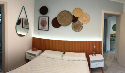 a bedroom with a bed and hats on the wall at Toninhas - Condomínio Wembley Tênis F201 in Ubatuba