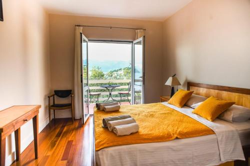 a bedroom with a large bed and a balcony at Boutique Hotel Tomić in Lopud Island