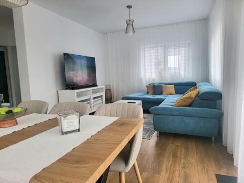 Sunset House spacious 3 bedrooms Baciu Cluj في Baciu: غرفة معيشة مع أريكة زرقاء وتلفزيون