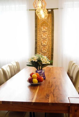 a dining room table with a bowl of fruit on it at Alpok – Spirit Apartman Park (Kőszegszerdahely) in Kőszeg