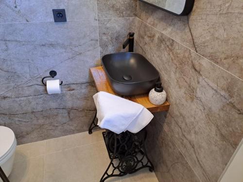a bathroom with a black bath tub and a toilet at Studio apartment Dalmatia in Nin