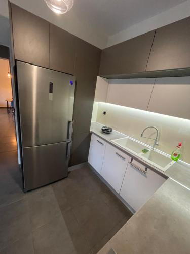 a kitchen with a stainless steel refrigerator and white cabinets at Villa Joanne in Alexandroupoli