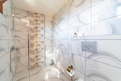 La salle de bains est pourvue d'une douche avec du carrelage blanc. dans l'établissement -VİLLA Vildan- 12 KİŞİLİK ÖZEL HAVUZLU 6 ODALI VİLLA, à Kemer