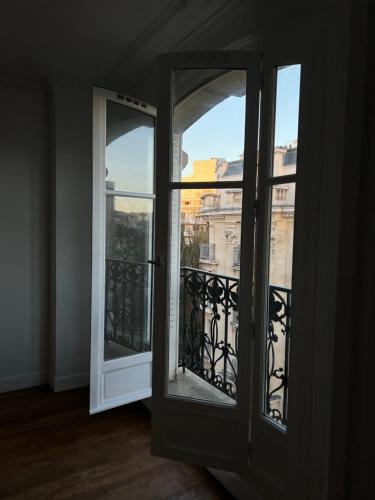 une porte ouverte avec vue sur un balcon dans l'établissement Bel appartement Haussmanien, à Paris