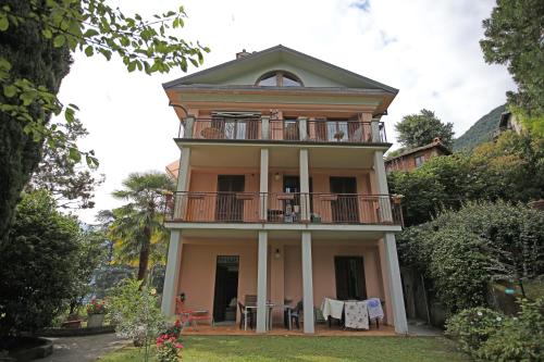 an old house with a balcony and a table at wonderful lake front appartment near Bellagio in Limonta