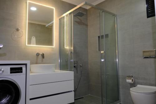 een badkamer met een douche en een wasmachine bij Mercan Suites Ilıca in Çeşme