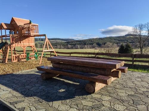 a wooden bench sitting next to a playground at Chata Jesenka in Čachrov