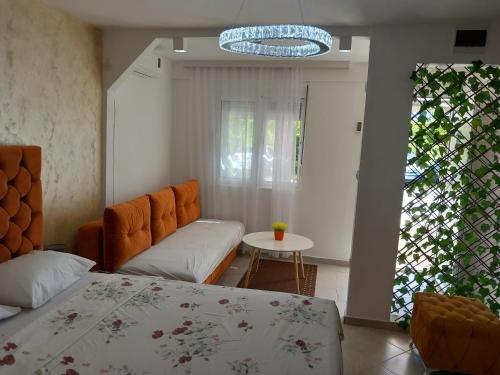 a bedroom with a bed and a couch and a table at Apartments Doha in Ulcinj