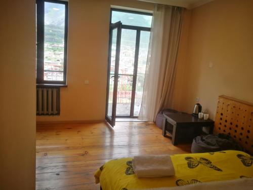 a room with a bed and a room with a window at Belas guesthouse in Stepantsminda