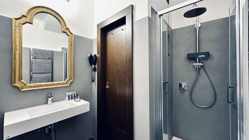 a bathroom with a shower and a sink and a mirror at Hotel Palazzo Piccolomini in Orvieto