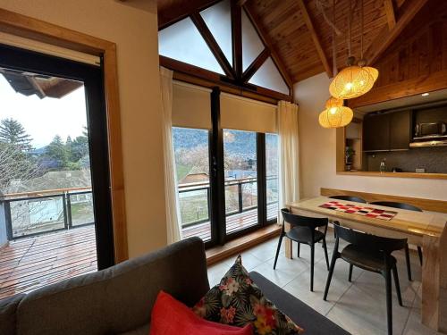 ein Wohnzimmer mit einem Sofa und einem Tisch mit Stühlen in der Unterkunft TERRAZAS DEL MASCARDI - LUXURY APARTMENT - INMEJORABLE UBICACION in San Martín de los Andes