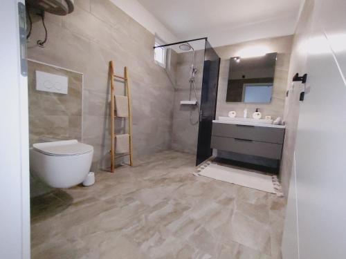 La salle de bains est pourvue de toilettes, d'un lavabo et d'un miroir. dans l'établissement Villa Ankica, à Tribunj