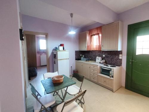 a kitchen with a table and chairs and a refrigerator at Little pomegranate apartment in Kapótidhes