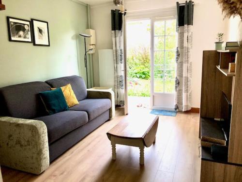 un salon avec un canapé et une table basse dans l'établissement Chambre du bout d'Auvers, à Noisy-sur-École