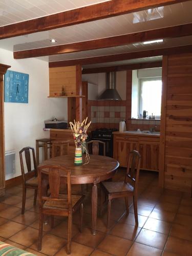 une cuisine avec une table et des chaises en bois dans l'établissement Gite Les Glycines 4 à 5 Personnes du samedi au samedi, à Plonéour-Lanvern