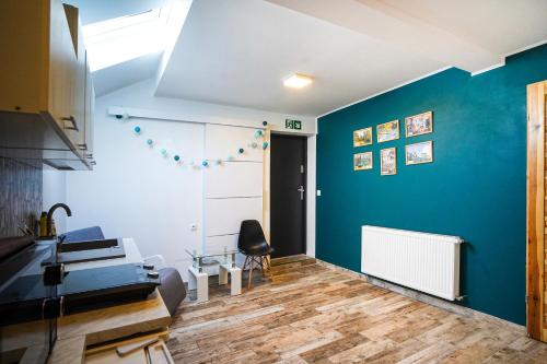 a living room with a blue wall and a chair at Willa Kwiatowa in Iwonicz-Zdrój