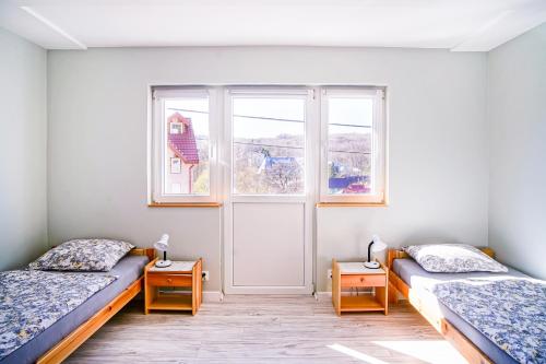 a room with two beds and a window at Willa Kwiatowa in Iwonicz-Zdrój